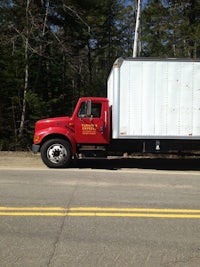 a red and white truck driving down a road