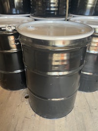 a group of black barrels sitting on a wooden floor