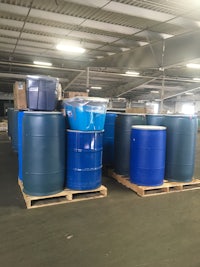 several blue barrels sitting on pallets in a warehouse